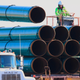 In this May 9, 2015, file photo, workers unload pipes for the proposed Dakota Access oil pipeline. Now, it’s operating, but developers want to push more oil through.